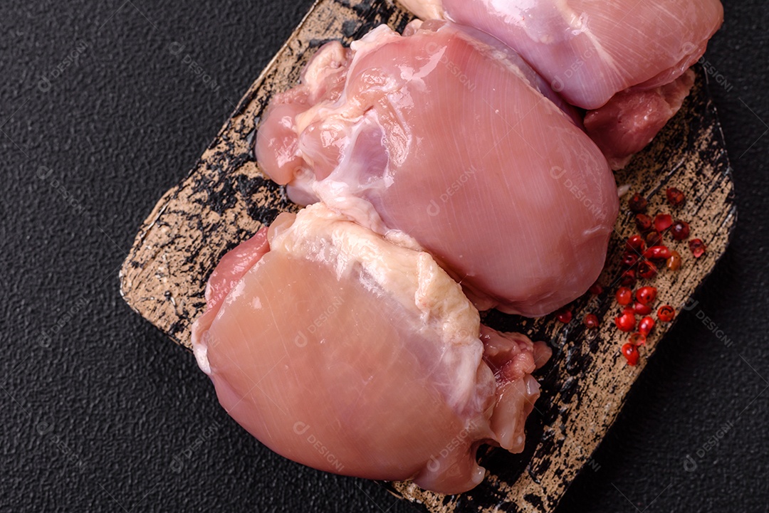 Retrato de sobrecoxas de frango cruas, desossadas e sem pele, prontas para preparo.