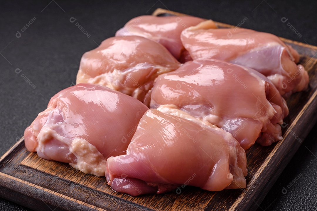 Retrato de sobrecoxas de frango cruas, desossadas e sem pele, prontas para preparo.