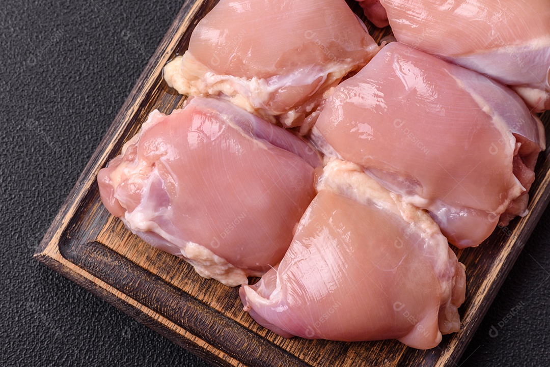 Retrato de sobrecoxas de frango cruas, desossadas e sem pele, prontas para preparo.