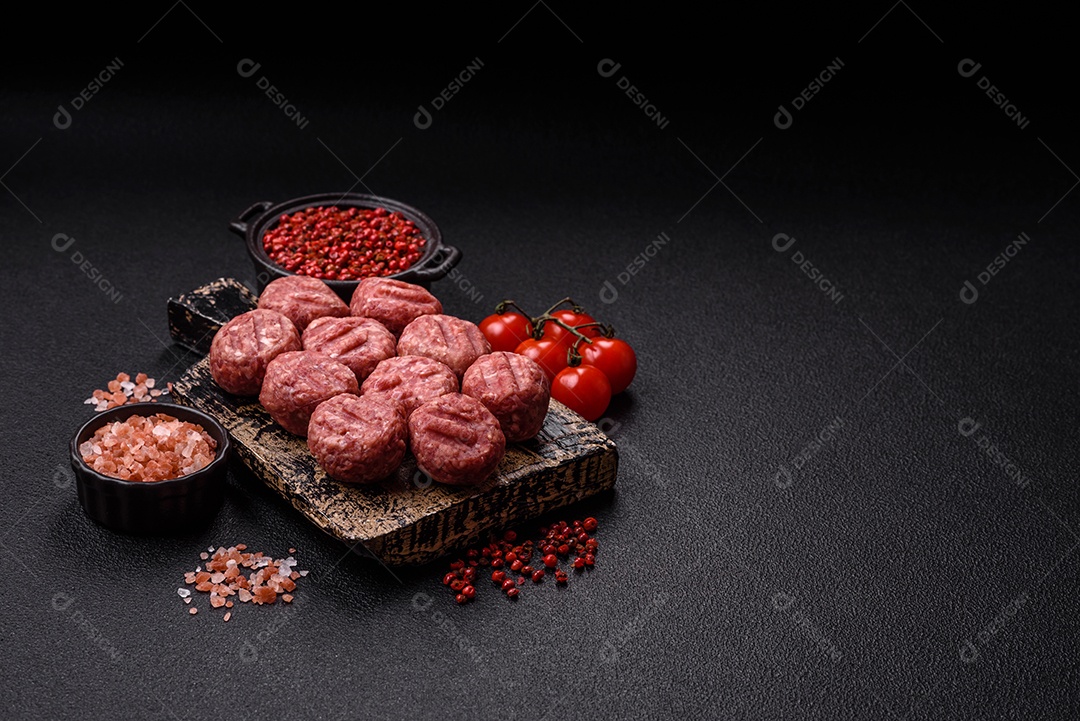 A imagem mostra almôndegas de carne cruas, prontas para serem cozidas, acompanhadas de tomates e pimenta rosa.