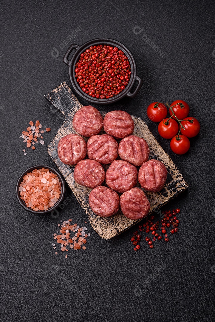 A imagem mostra almôndegas de carne cruas, prontas para serem cozidas, acompanhadas de tomates e pimenta rosa.