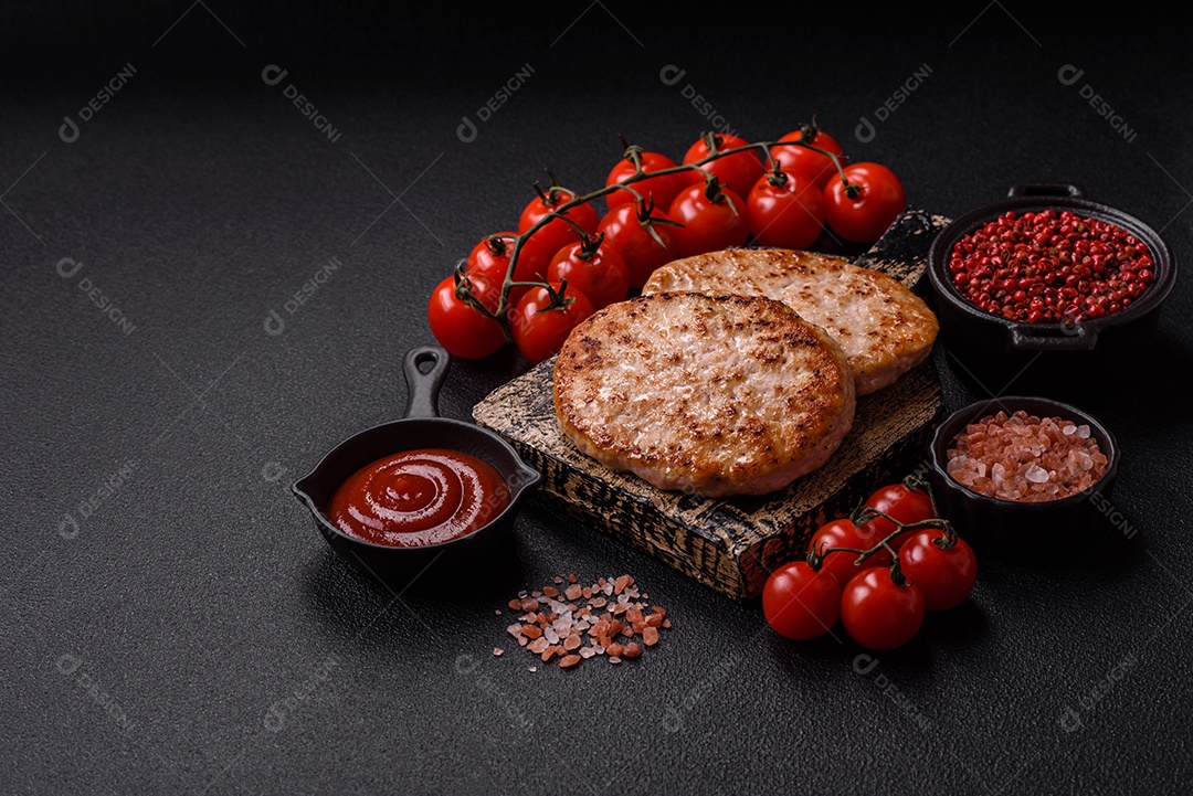 A imagem mostra chuletas de porco grelhadas, acompanhadas de ramos de tomilho e tomates cereja.