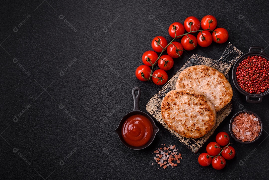 A imagem mostra chuletas de porco grelhadas, acompanhadas de ramos de tomilho e tomates cereja.