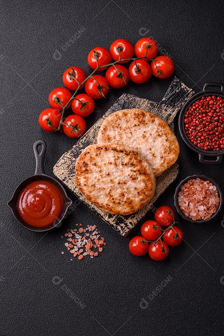 A imagem mostra chuletas de porco grelhadas, acompanhadas de ramos de tomilho e tomates cereja.