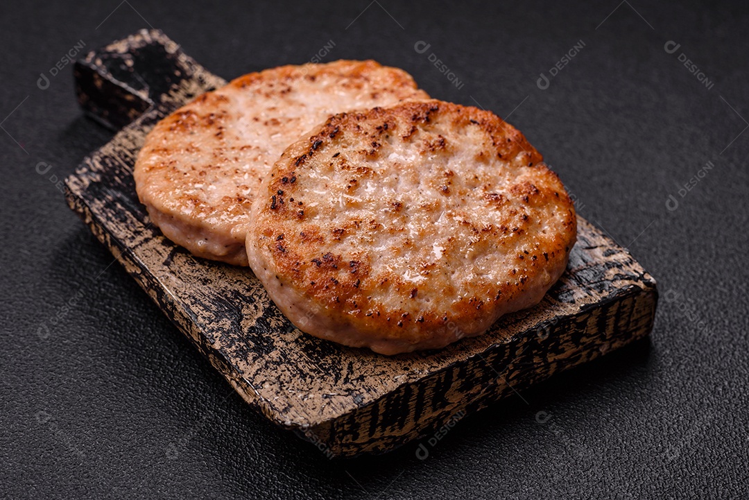 A imagem mostra chuletas de porco grelhadas, acompanhadas de ramos de tomilho e tomates cereja.