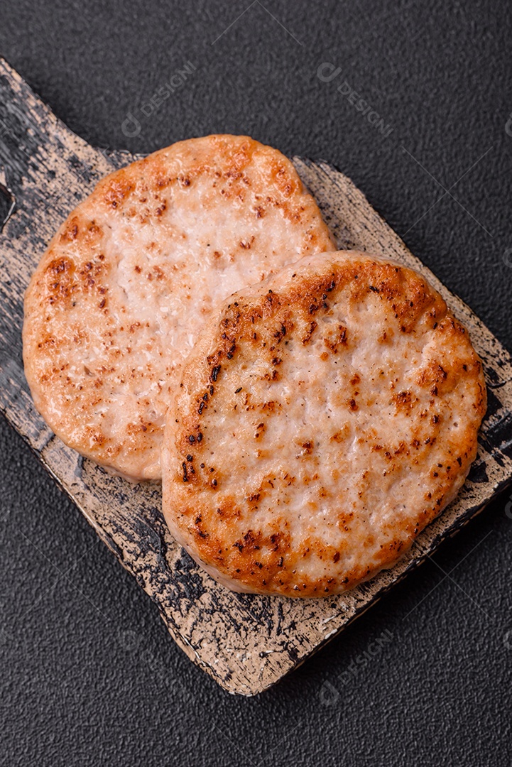A imagem mostra chuletas de porco grelhadas, acompanhadas de ramos de tomilho e tomates cereja.