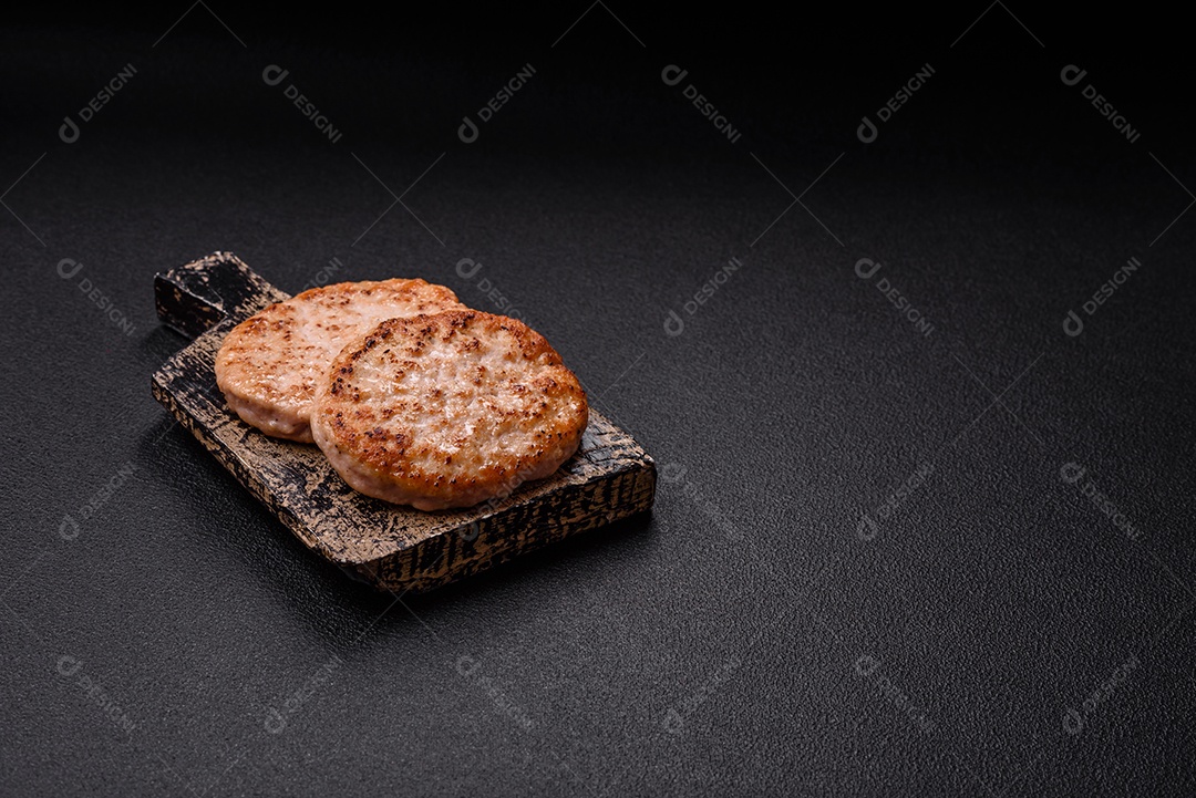 A imagem mostra chuletas de porco grelhadas, acompanhadas de ramos de tomilho e tomates cereja.