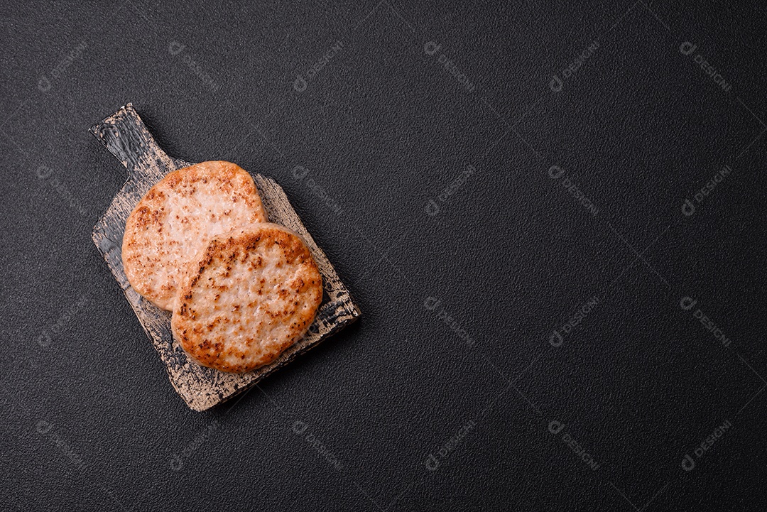 A imagem mostra chuletas de porco grelhadas, acompanhadas de ramos de tomilho e tomates cereja.
