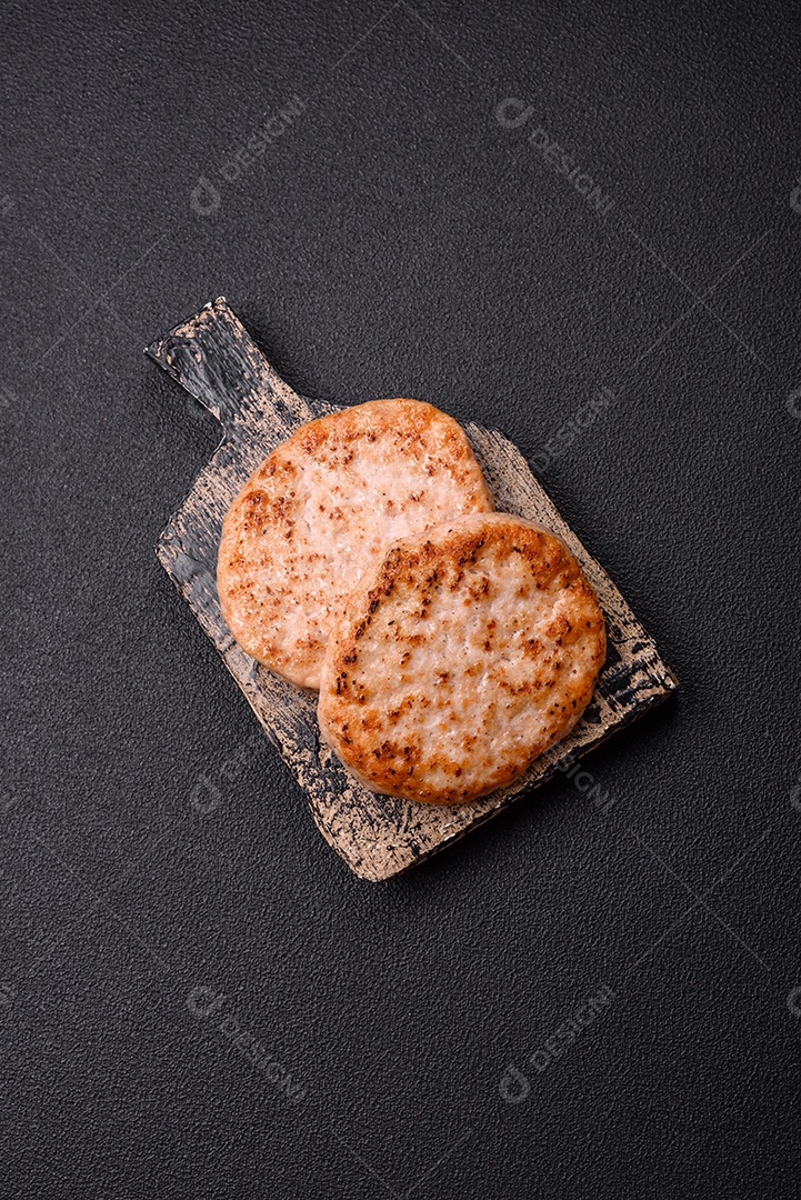 A imagem mostra chuletas de porco grelhadas, acompanhadas de ramos de tomilho e tomates cereja.