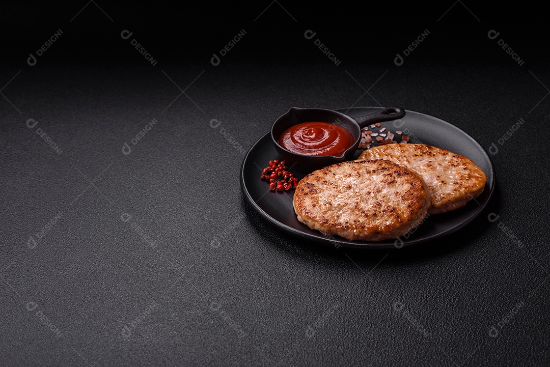 A imagem mostra chuletas de porco grelhadas, acompanhadas de ramos de tomilho e tomates cereja.