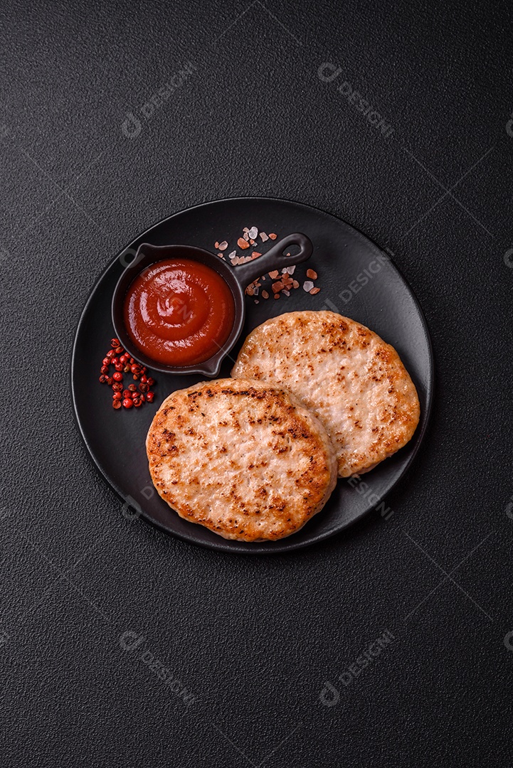 A imagem mostra chuletas de porco grelhadas, acompanhadas de ramos de tomilho e tomates cereja.