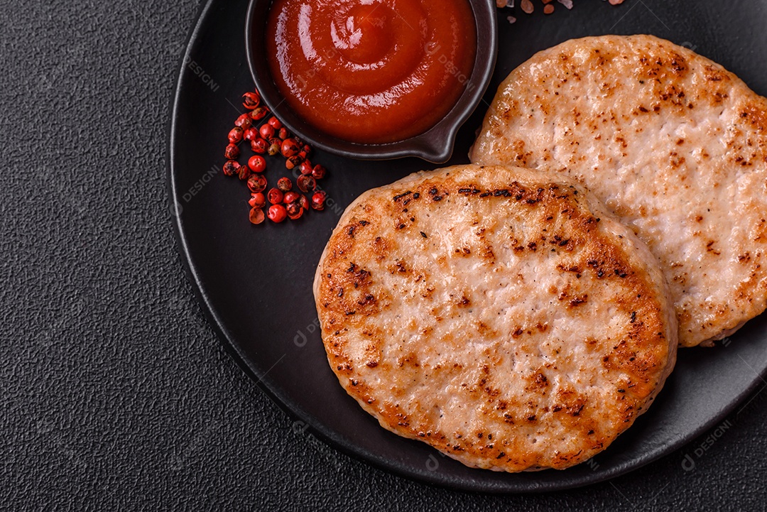 A imagem mostra chuletas de porco grelhadas, acompanhadas de ramos de tomilho e tomates cereja.