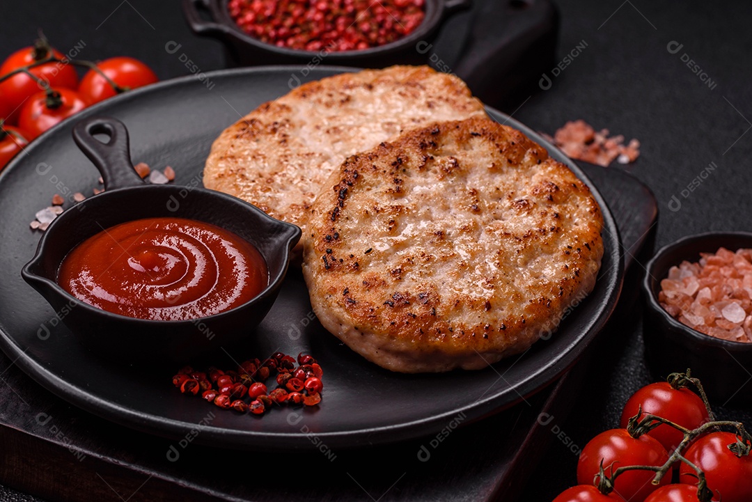 A imagem mostra chuletas de porco grelhadas, acompanhadas de ramos de tomilho e tomates cereja.