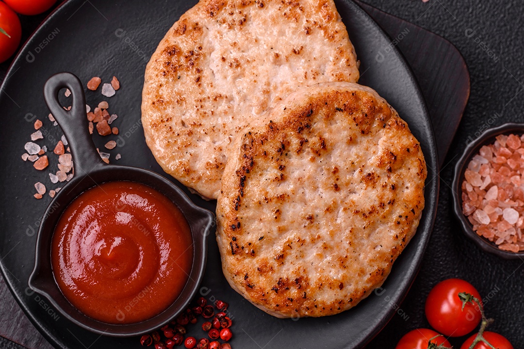 A imagem mostra chuletas de porco grelhadas, acompanhadas de ramos de tomilho e tomates cereja.