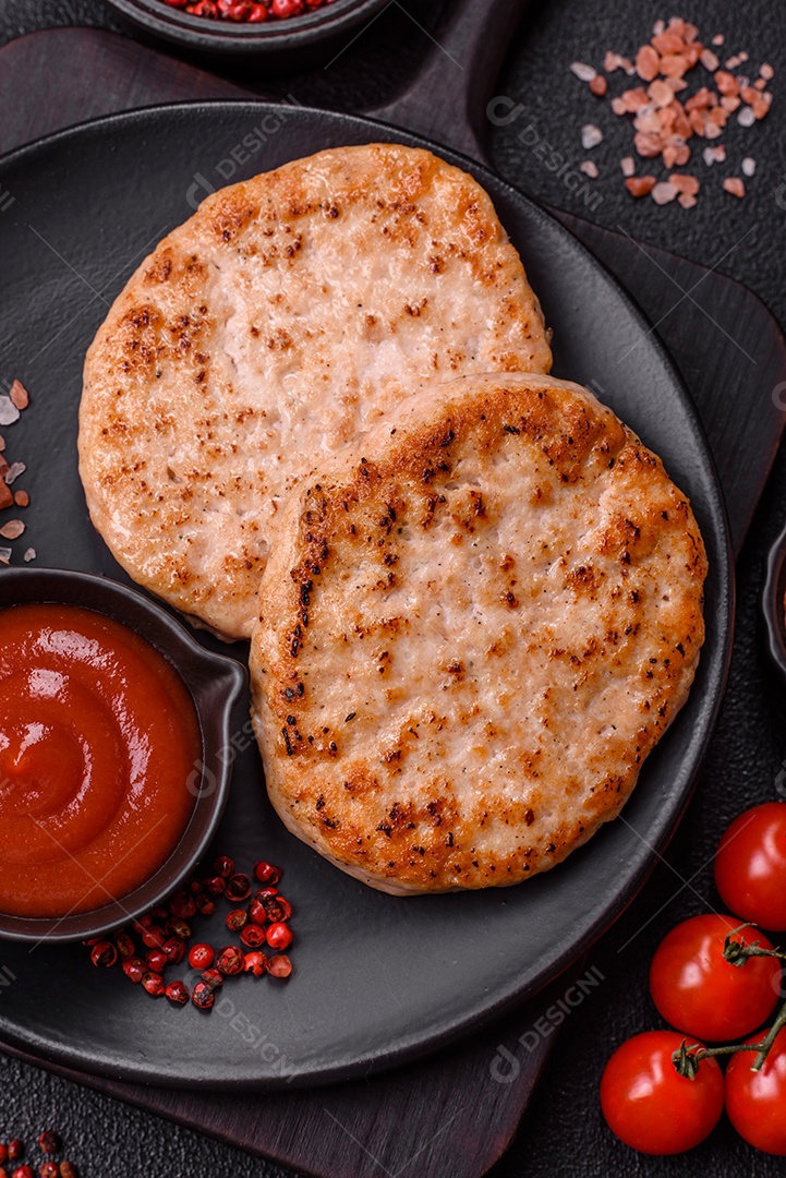 A imagem mostra chuletas de porco grelhadas, acompanhadas de ramos de tomilho e tomates cereja.