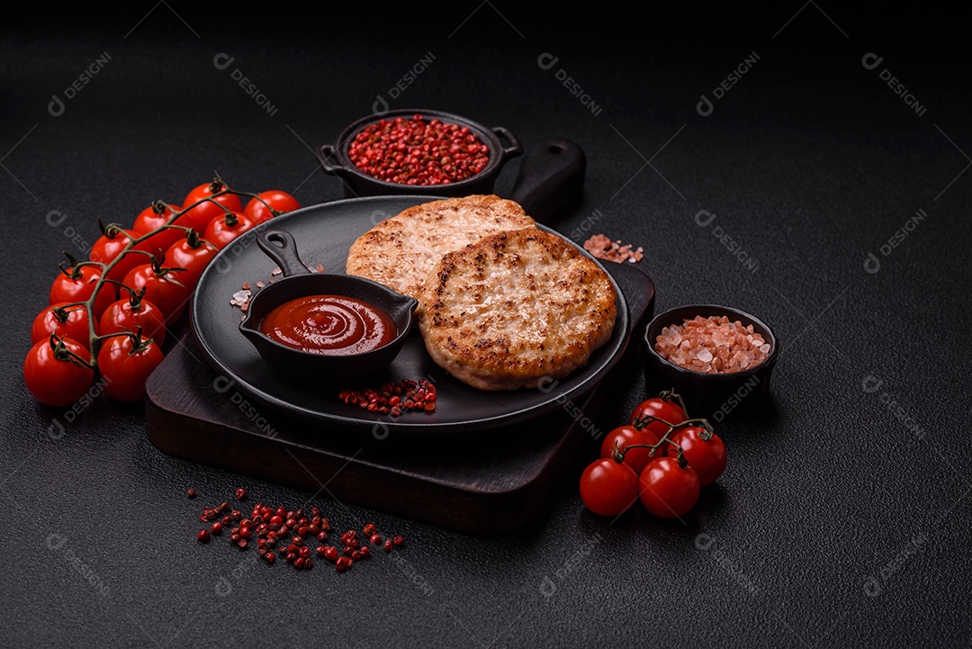 A imagem mostra chuletas de porco grelhadas, acompanhadas de ramos de tomilho e tomates cereja.