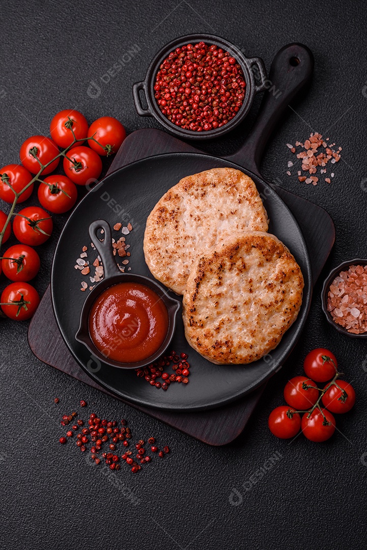 A imagem mostra chuletas de porco grelhadas, acompanhadas de ramos de tomilho e tomates cereja.
