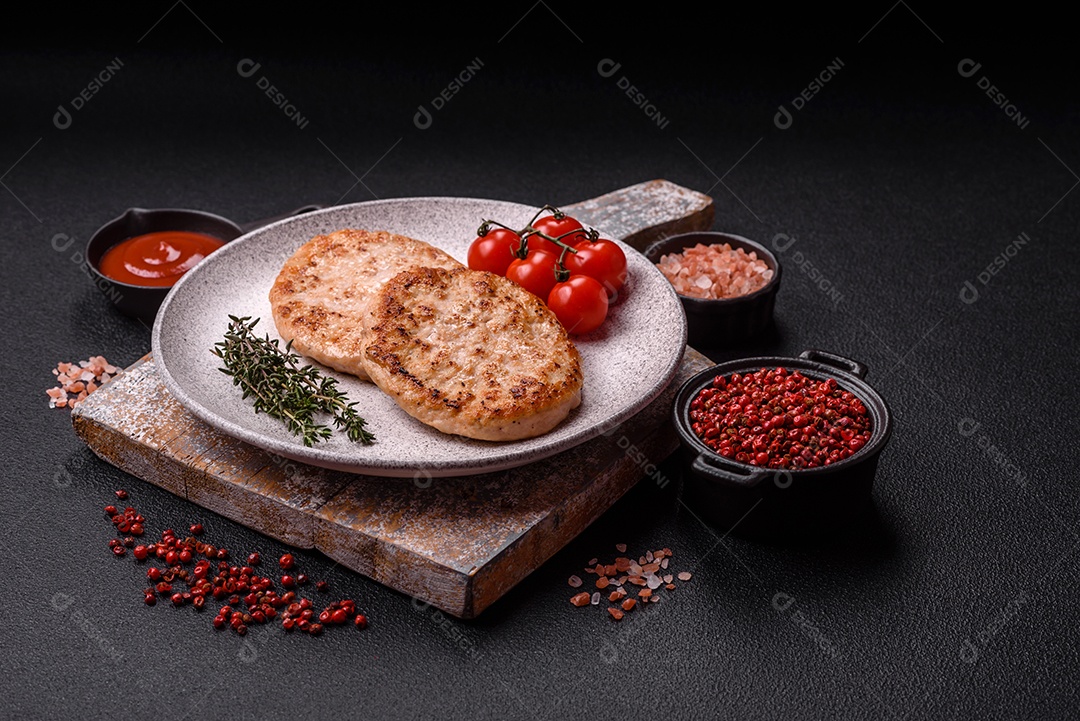 A imagem mostra chuletas de porco grelhadas, acompanhadas de ramos de tomilho e tomates cereja.