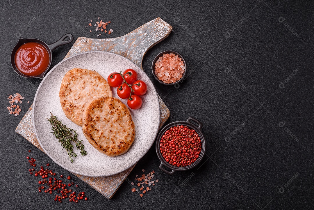 A imagem mostra chuletas de porco grelhadas, acompanhadas de ramos de tomilho e tomates cereja.