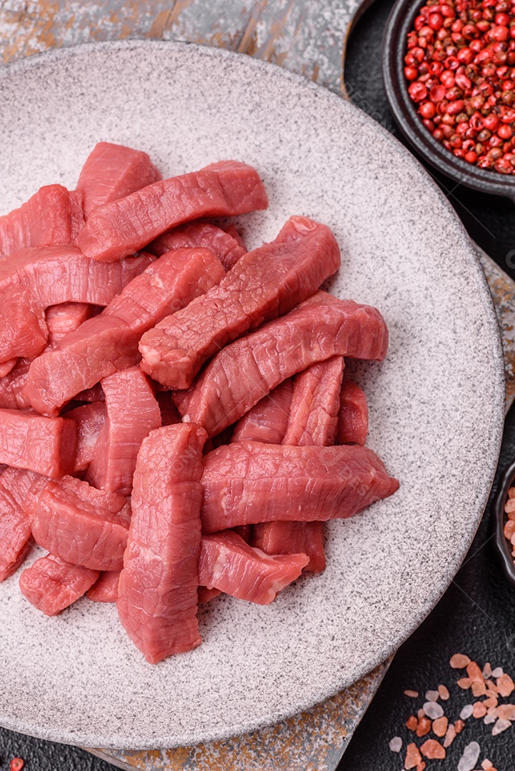 Carne bovina crua cortada em tiras Tomates cereja Sal rosa do Himalaia Pimenta em grãos