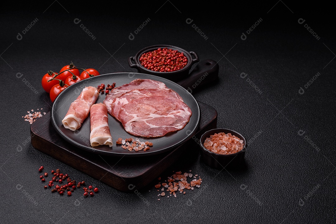 A imagem mostra um prato de embutidos, com destaque para fatias de salame e presunto cru, acompanhados de tomates-cereja e pimenta rosa