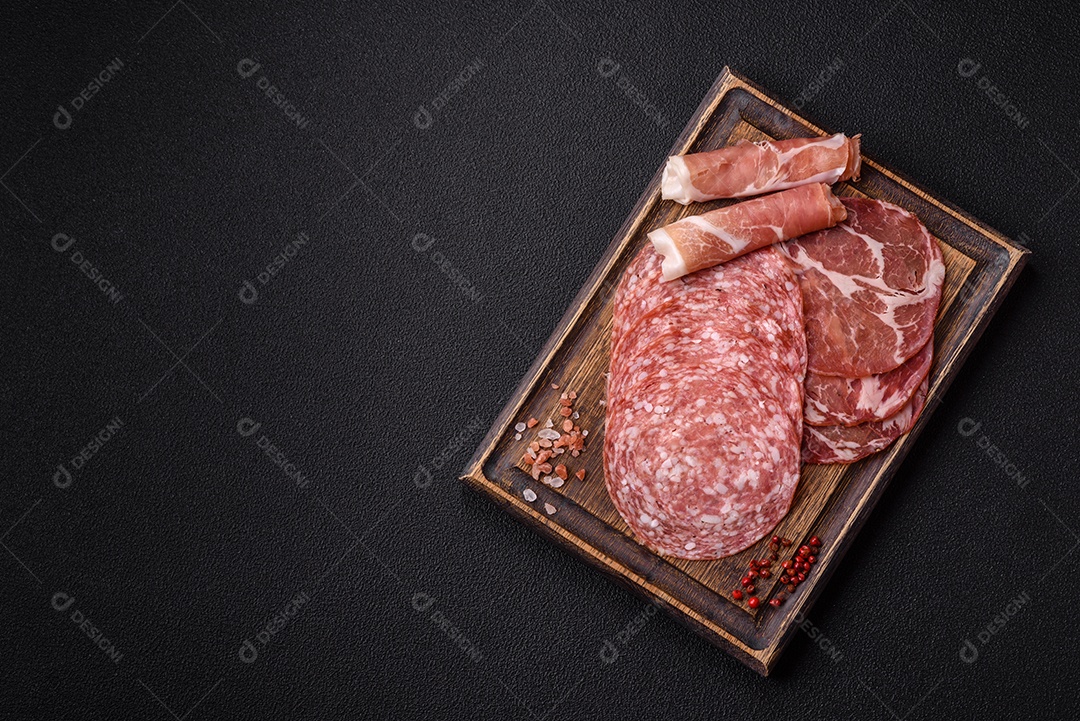 A imagem mostra um prato de embutidos, com destaque para fatias de salame e presunto cru, acompanhados de tomates-cereja e pimenta rosa