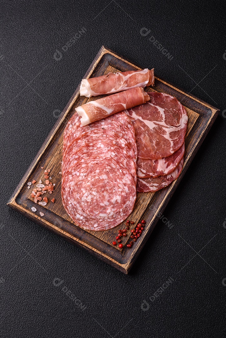 A imagem mostra um prato de embutidos, com destaque para fatias de salame e presunto cru, acompanhados de tomates-cereja e pimenta rosa