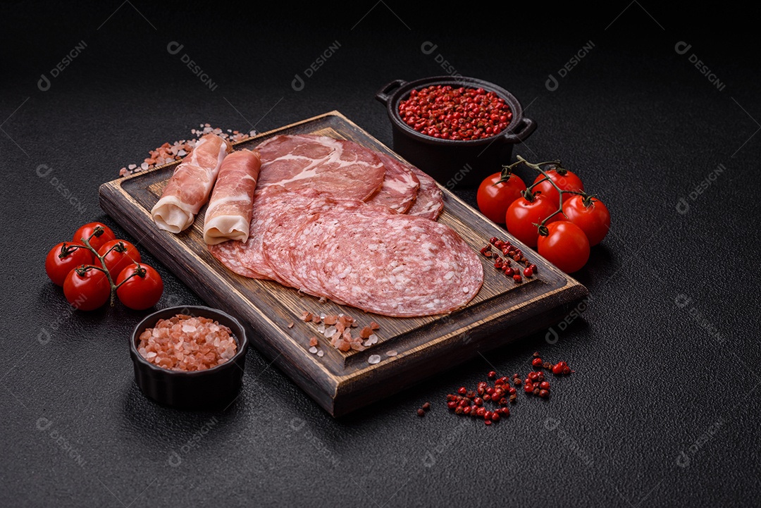 A imagem mostra um prato de embutidos, com destaque para fatias de salame e presunto cru, acompanhados de tomates-cereja e pimenta rosa