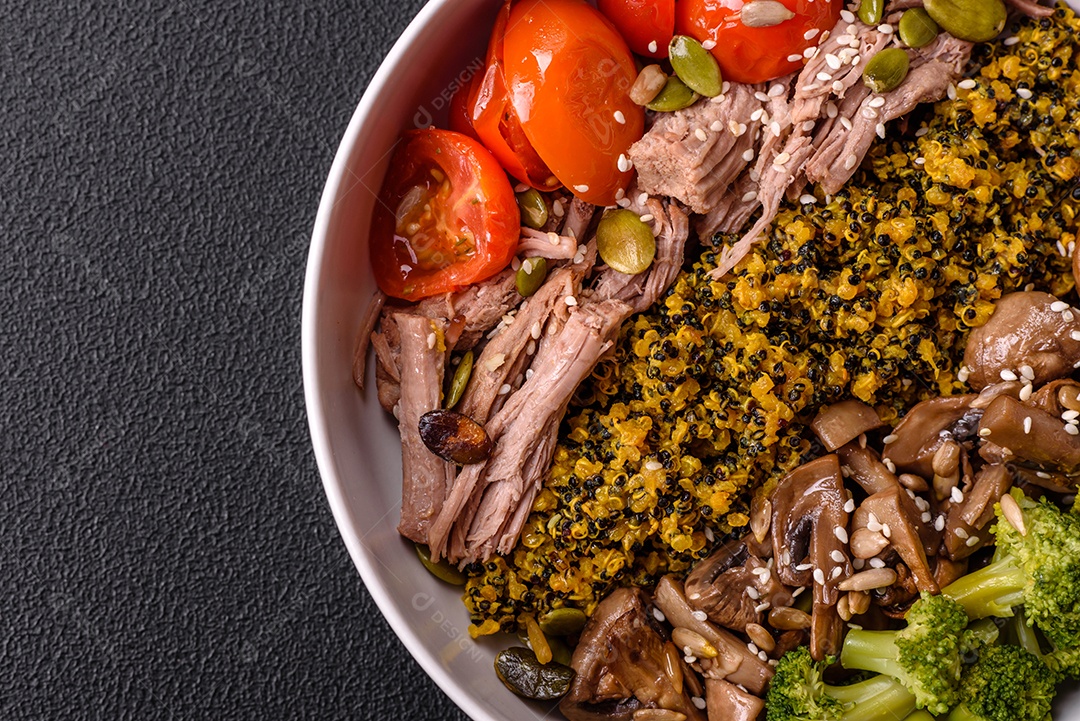 A imagem mostra uma tigela de quinoa com brócolis, cogumelos, carne desfiada (possivelmente frango ou carne bovina), tomate cereja e sementes de abóbora