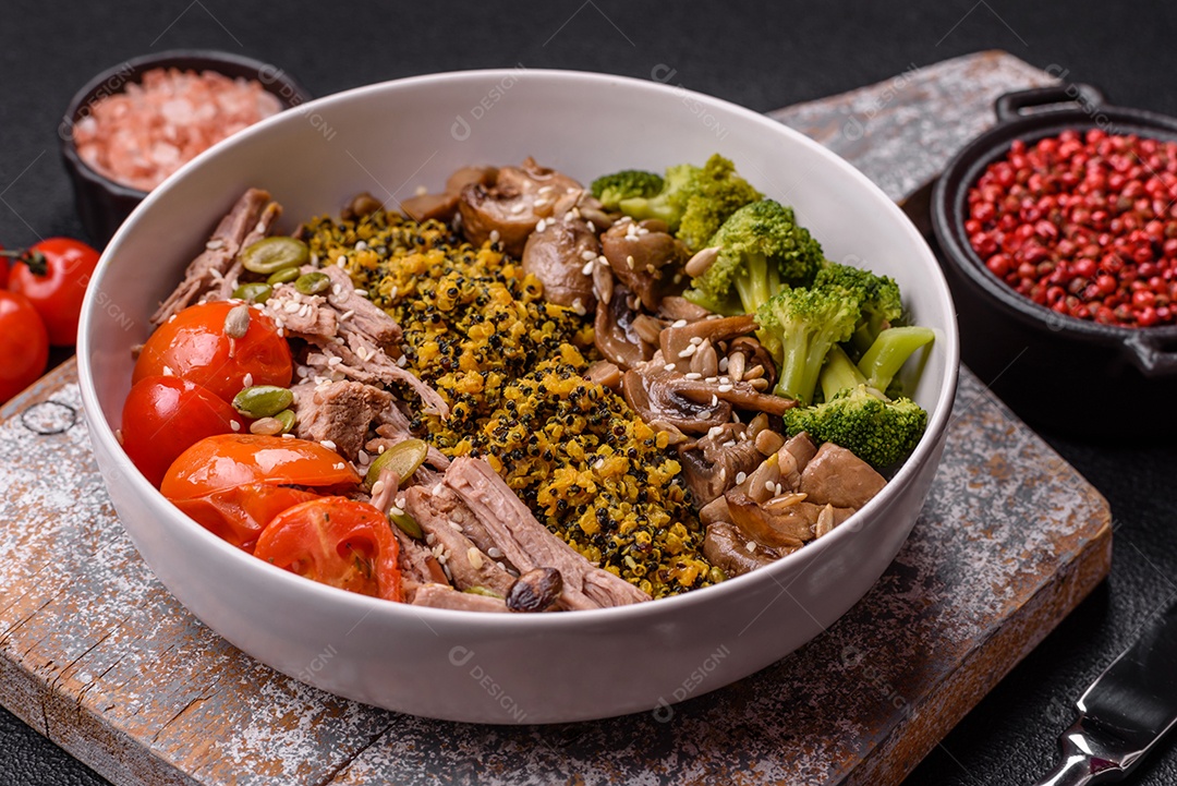A imagem mostra uma tigela de quinoa com brócolis, cogumelos, carne desfiada (possivelmente frango ou carne bovina), tomate cereja e sementes de abóbora
