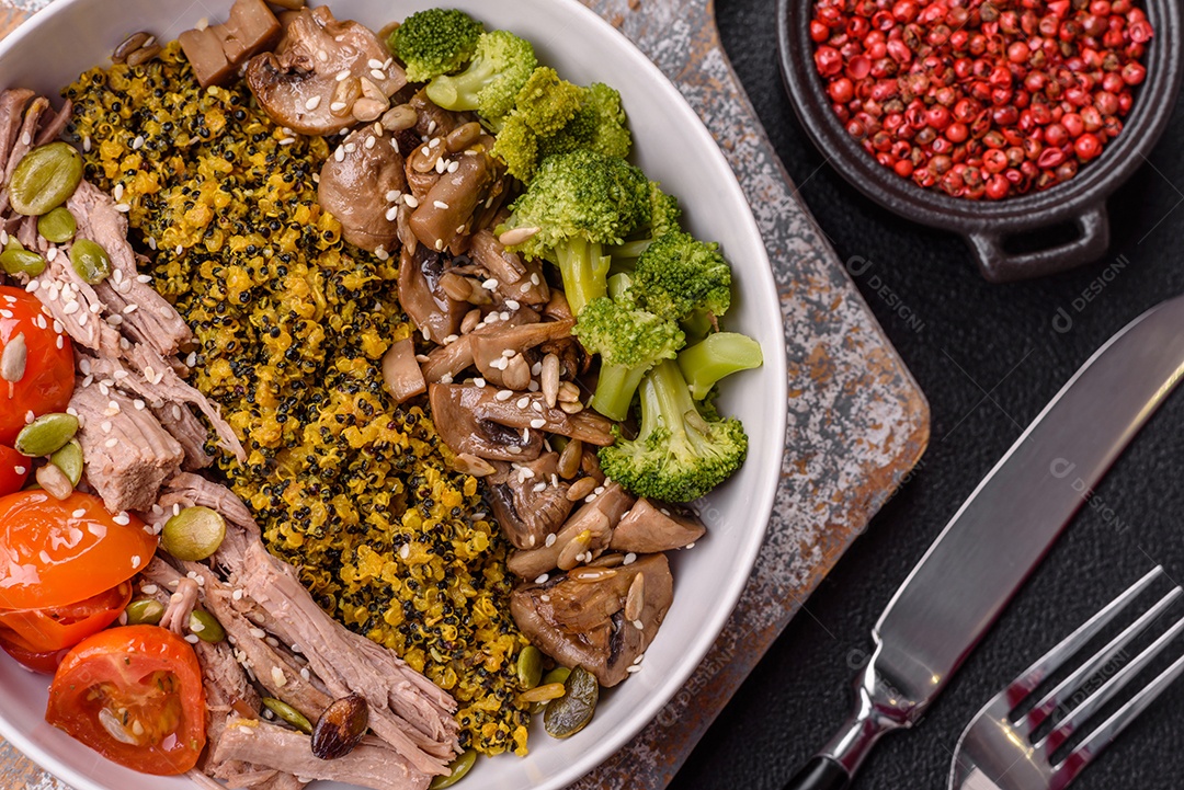 A imagem mostra uma tigela de quinoa com brócolis, cogumelos, carne desfiada (possivelmente frango ou carne bovina), tomate cereja e sementes de abóbora