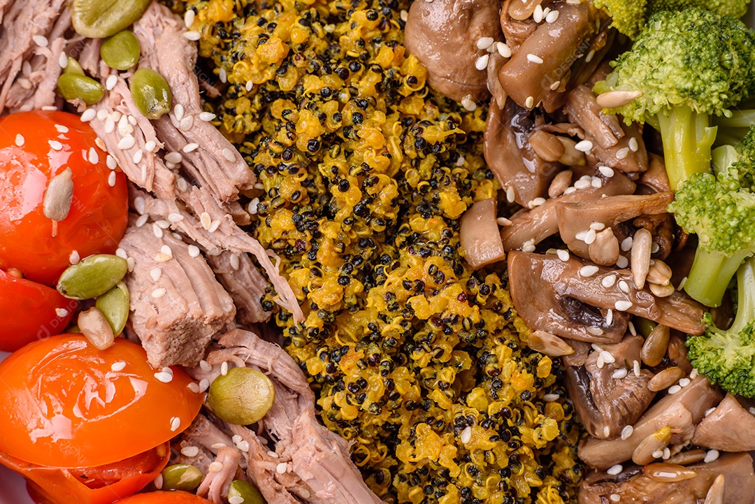 A imagem mostra uma tigela de quinoa com brócolis, cogumelos, carne desfiada (possivelmente frango ou carne bovina), tomate cereja e sementes de abóbora