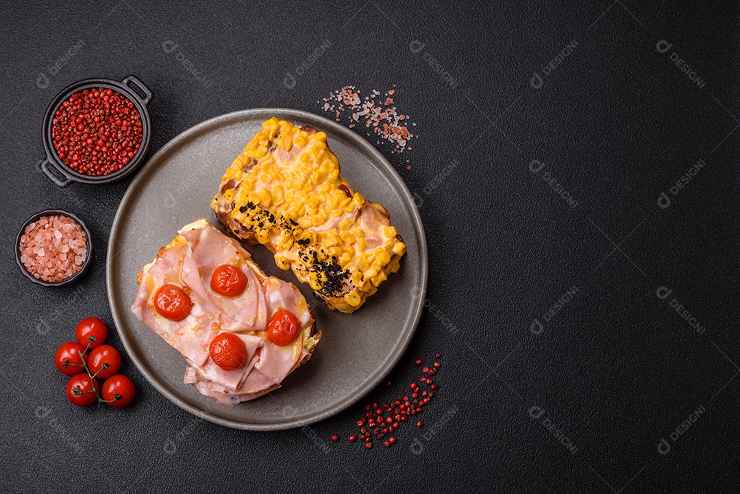 A imagem mostra um sanduíche de brioche com presunto, queijo derretido e tomates cereja, polvilhado com sal e pimenta.
