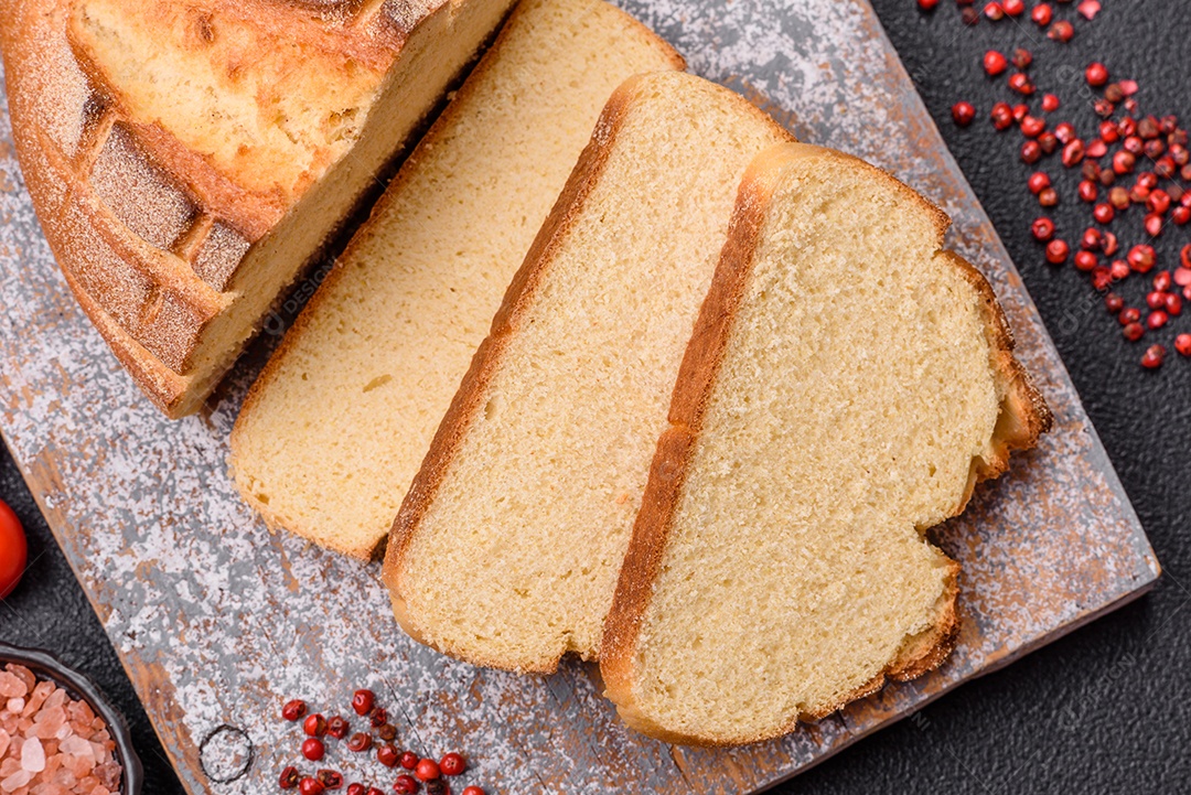 A imagem mostra pão integral fatiado, acompanhado de tomates cereja, sal rosa