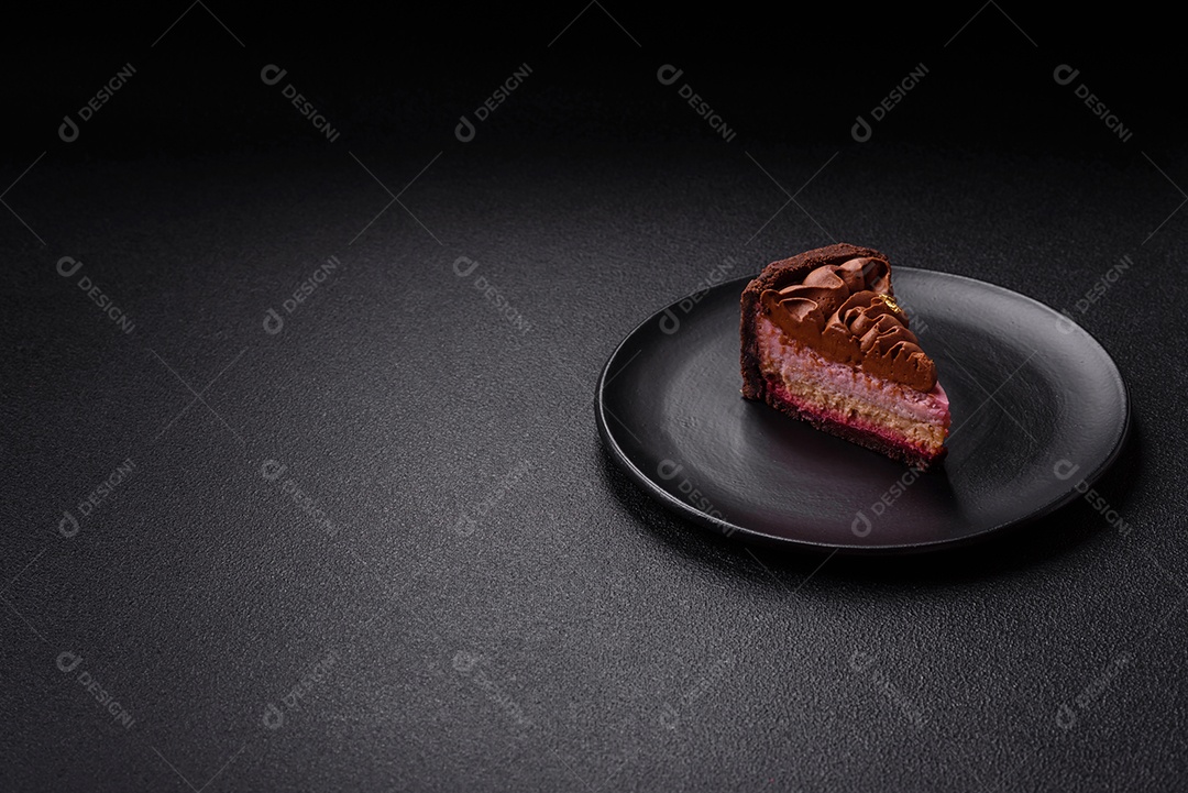 A imagem mostra uma fatia de bolo ou torta de chocolate, possivelmente com uma camada de recheio ou cobertura de cor diferente, decorada com rodelas de laranja