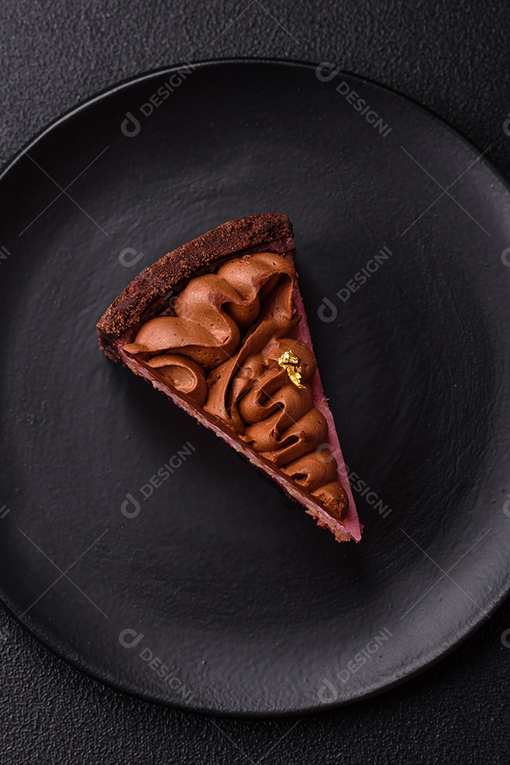 A imagem mostra uma fatia de bolo ou torta de chocolate, possivelmente com uma camada de recheio ou cobertura de cor diferente, decorada com rodelas de laranja
