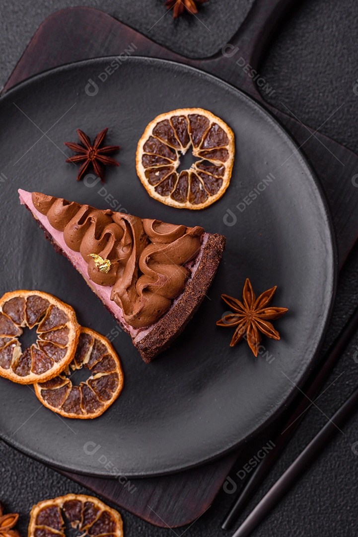 A imagem mostra uma fatia de bolo ou torta de chocolate, possivelmente com uma camada de recheio ou cobertura de cor diferente, decorada com rodelas de laranja