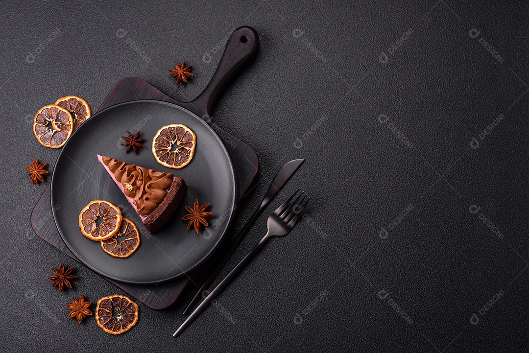 A imagem mostra uma fatia de bolo ou torta de chocolate, possivelmente com uma camada de recheio ou cobertura de cor diferente, decorada com rodelas de laranja