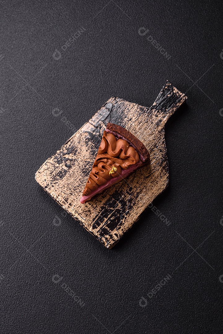 A imagem mostra uma fatia de bolo ou torta de chocolate, possivelmente com uma camada de recheio ou cobertura de cor diferente, decorada com rodelas de laranja