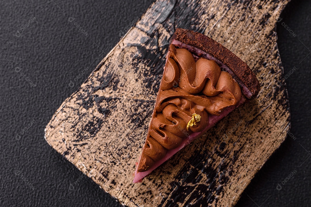 A imagem mostra uma fatia de bolo ou torta de chocolate, possivelmente com uma camada de recheio ou cobertura de cor diferente, decorada com rodelas de laranja