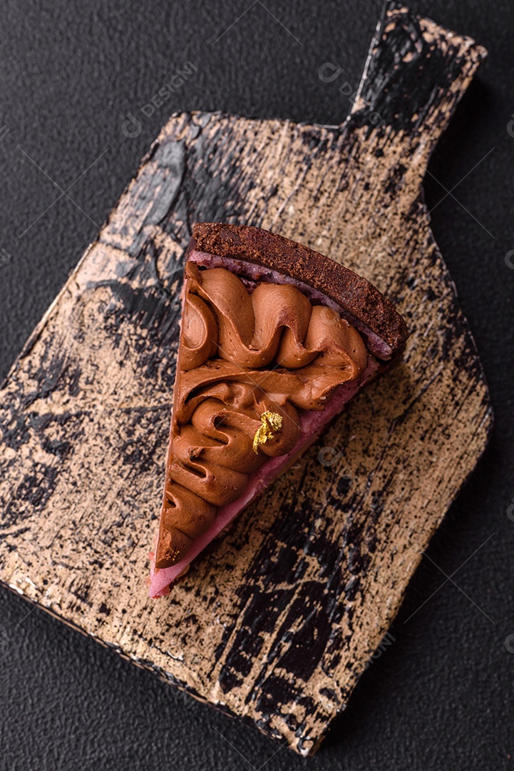 A imagem mostra uma fatia de bolo ou torta de chocolate, possivelmente com uma camada de recheio ou cobertura de cor diferente, decorada com rodelas de laranja