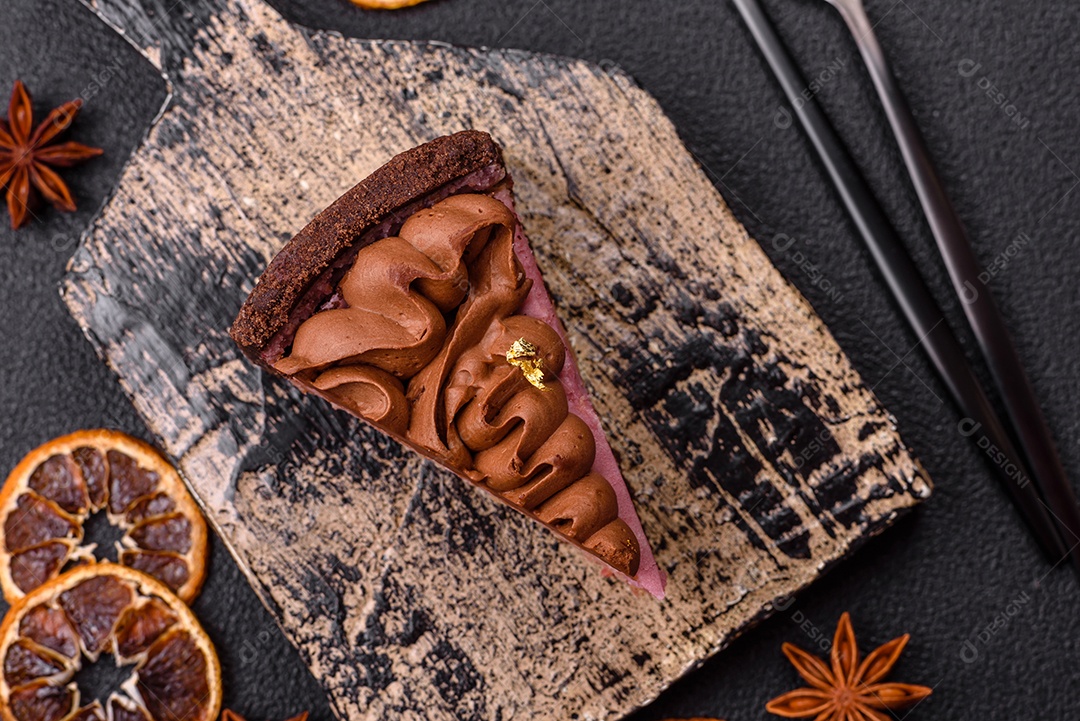 A imagem mostra uma fatia de bolo ou torta de chocolate, possivelmente com uma camada de recheio ou cobertura de cor diferente, decorada com rodelas de laranja