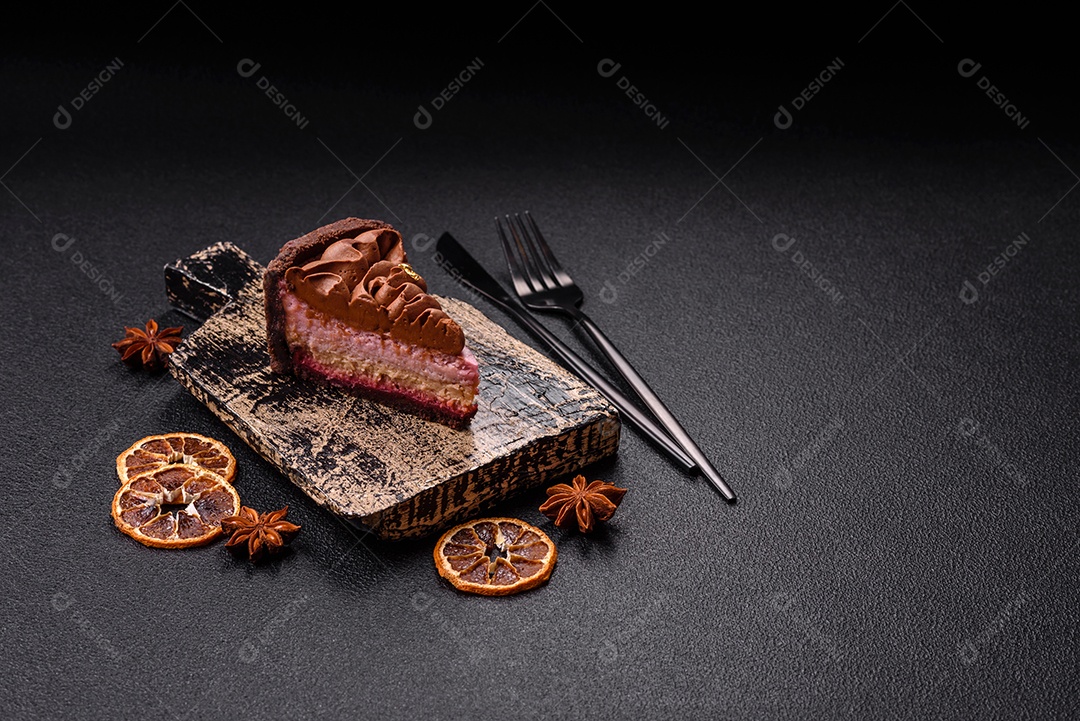 A imagem mostra uma fatia de bolo ou torta de chocolate, possivelmente com uma camada de recheio ou cobertura de cor diferente, decorada com rodelas de laranja