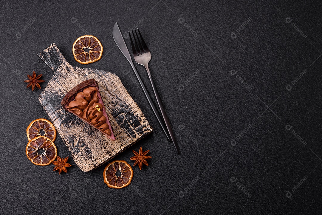 A imagem mostra uma fatia de bolo ou torta de chocolate, possivelmente com uma camada de recheio ou cobertura de cor diferente, decorada com rodelas de laranja