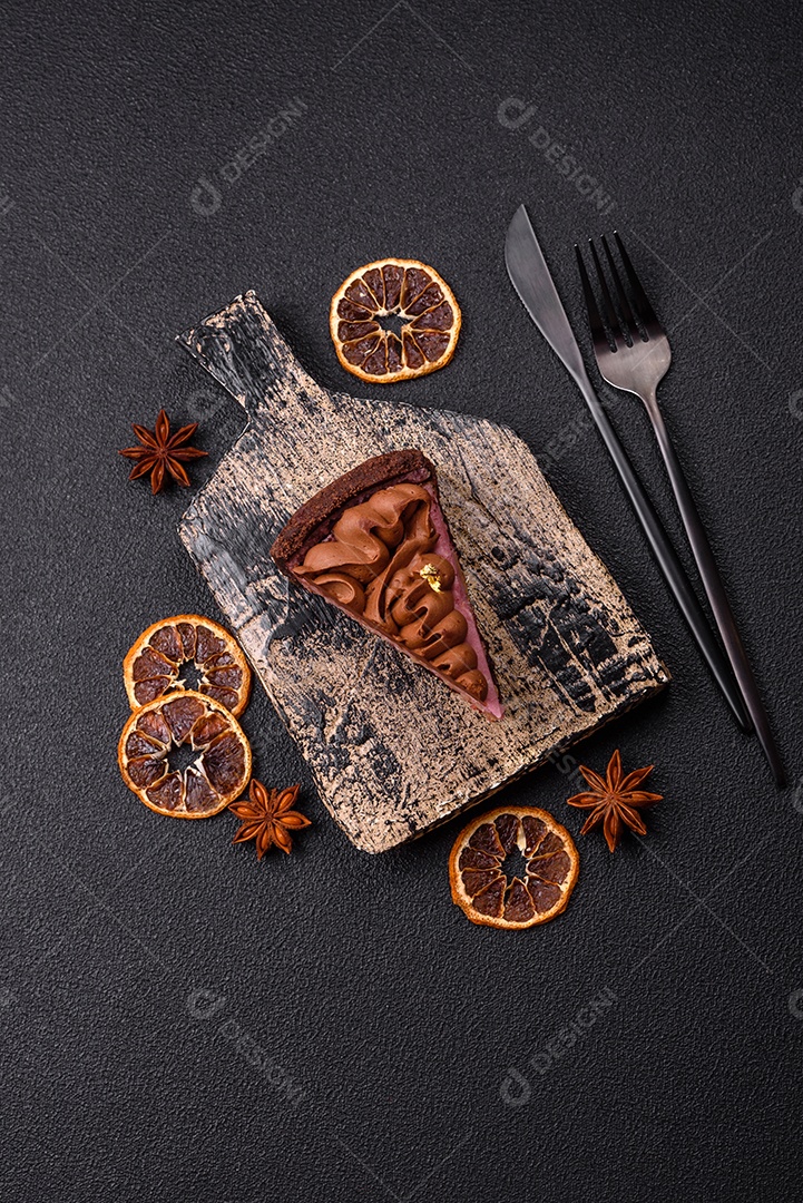 A imagem mostra uma fatia de bolo ou torta de chocolate, possivelmente com uma camada de recheio ou cobertura de cor diferente, decorada com rodelas de laranja