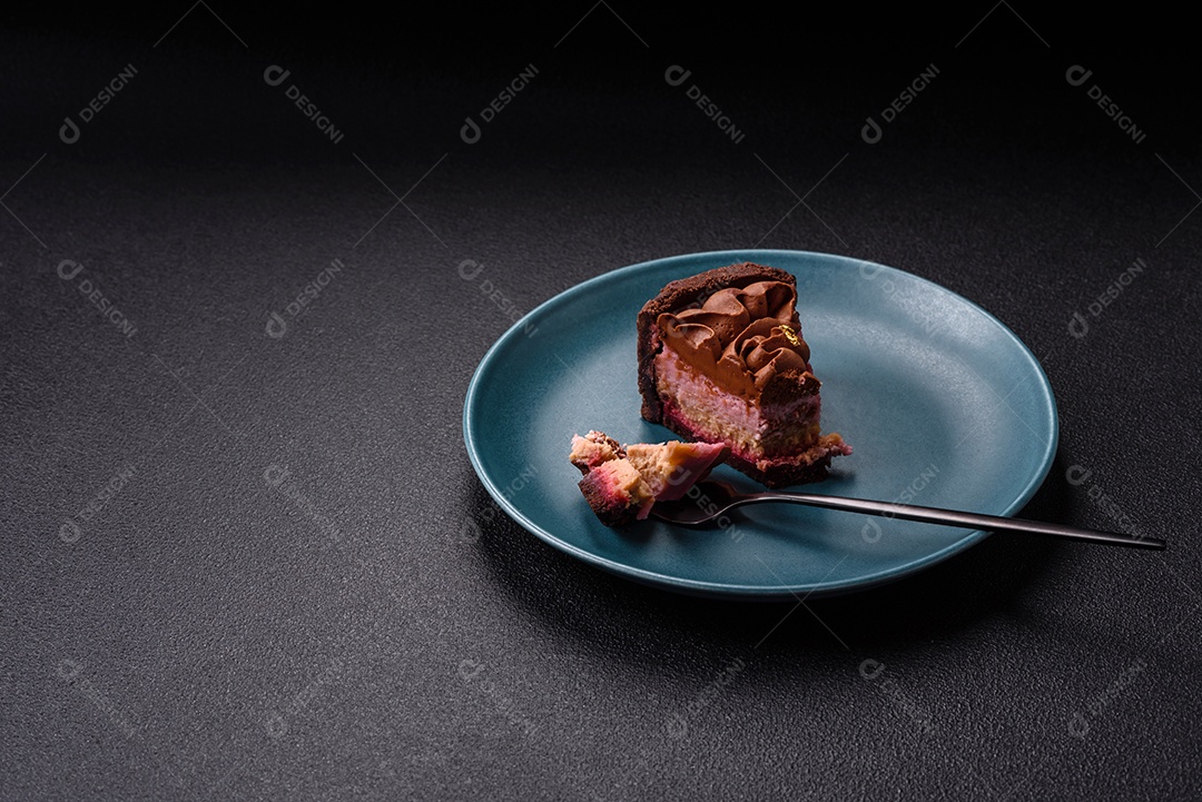 A imagem mostra uma fatia de bolo ou torta de chocolate, possivelmente com uma camada de recheio ou cobertura de cor diferente, decorada com rodelas de laranja