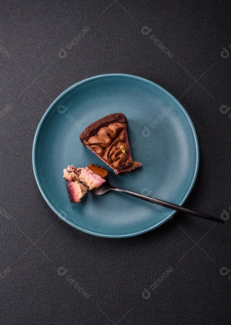 A imagem mostra uma fatia de bolo ou torta de chocolate, possivelmente com uma camada de recheio ou cobertura de cor diferente, decorada com rodelas de laranja