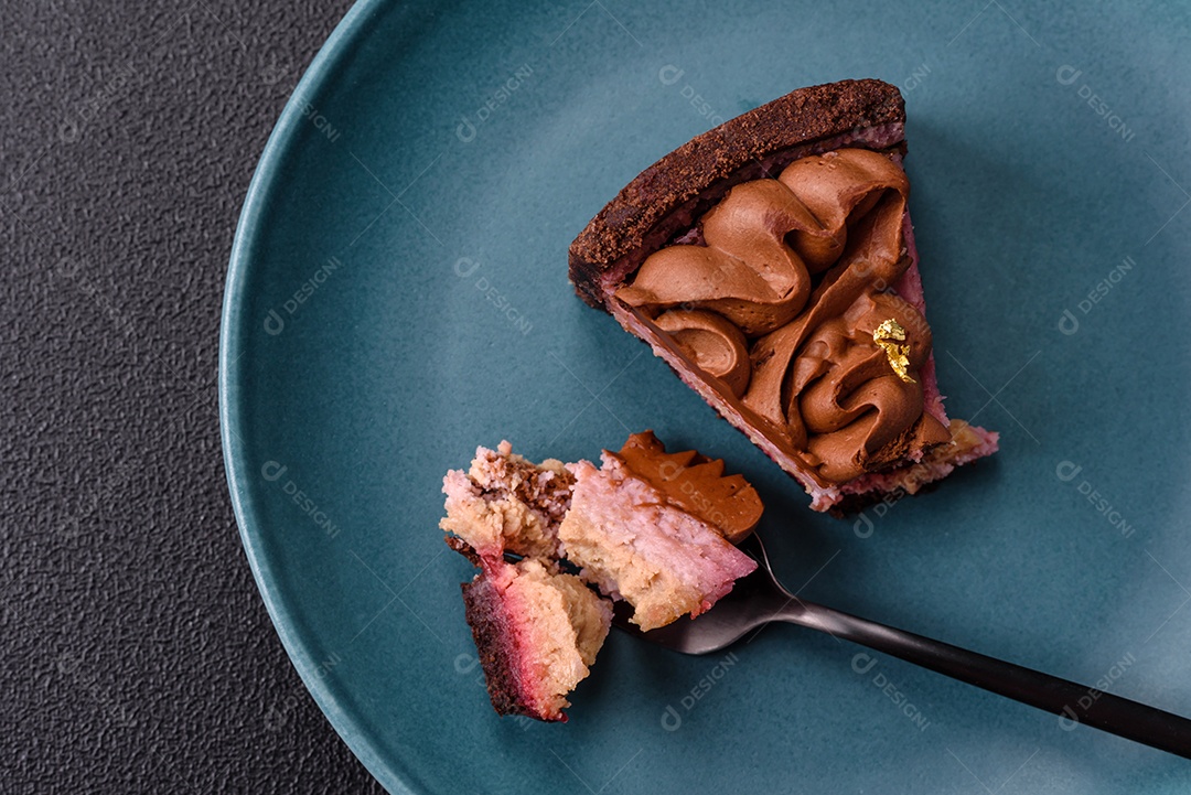 A imagem mostra uma fatia de bolo ou torta de chocolate, possivelmente com uma camada de recheio ou cobertura de cor diferente, decorada com rodelas de laranja