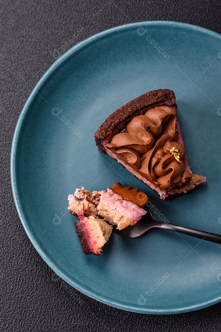 A imagem mostra uma fatia de bolo ou torta de chocolate, possivelmente com uma camada de recheio ou cobertura de cor diferente, decorada com rodelas de laranja