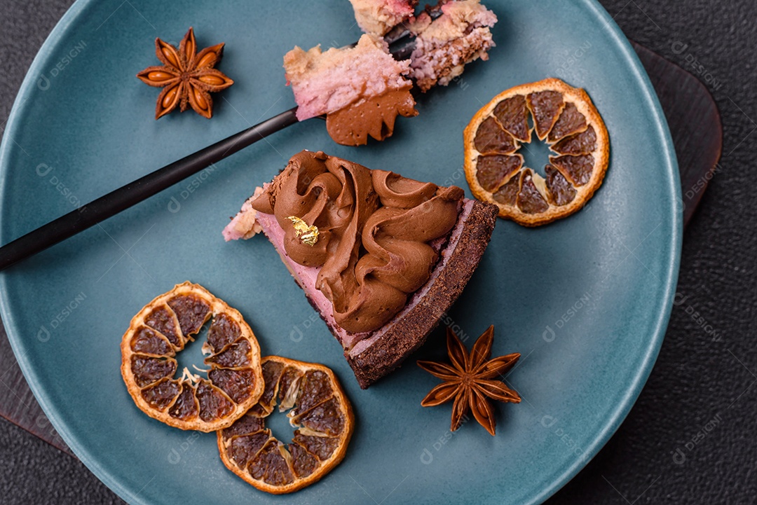 A imagem mostra uma fatia de bolo ou torta de chocolate, possivelmente com uma camada de recheio ou cobertura de cor diferente, decorada com rodelas de laranja